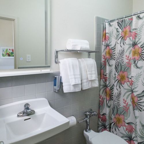 Refresh and rejuvenate in our immaculate bathroom, boasting fresh towels, essential toiletries, and a clean, spacious vanity for your convenience.