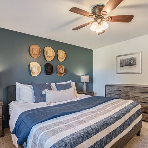 Dive into the modern cowboy-themed charm of the third upper-level bedroom, featuring a king-size bed adorned with contemporary linens.