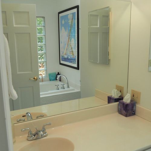 Bathroom #2 (main floor):  this is a private en suite bathroom for the master bedroom (bedroom #1). Features 2 sinks, a large bathtub, and separate shower and toilet facilities.