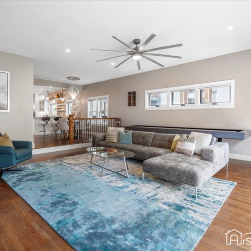 This plush living room features an extra-large sectional for ultimate relaxation and a shuffleboard table for endless entertainment.