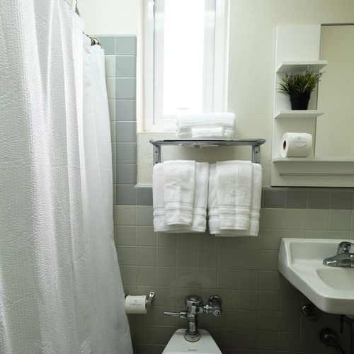 Find everything you need in our clean and functional bathroom, featuring plenty of fresh towels and a well-maintained space to ensure your comfort.