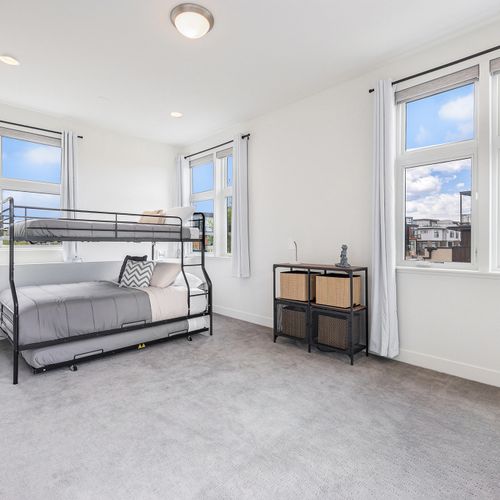 This well-lit space hosts a comfortable, industrial-chic bunk bed with clean, minimalist lines.