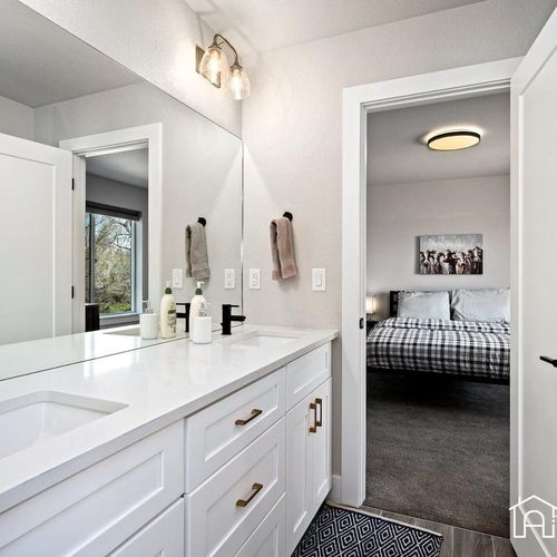 - dual sink vanity connects two bedrooms in this smart jack and jill bathroom setup
- black fixtures and white cabinetry create a clean modern aesthetic
- wide mirror and soft lighting make shared space feel bright and balanced