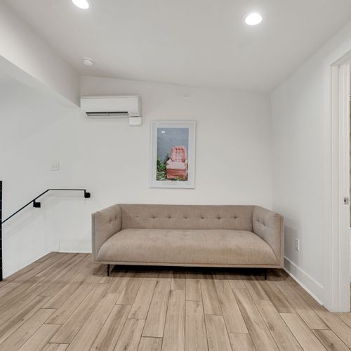 A quiet landing space with a comfy sofa and direct access to a full bathroom—perfect for reading or a private moment.