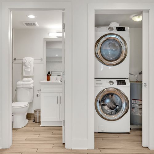 Stay fresh with the convenience of a washer and dryer right next to a bright, modern bathroom stocked with essentials.