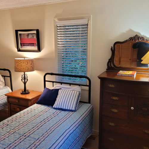 Bedroom #3 (first floor):  features two twin beds, dresser, closet, nightstand, and lamps.