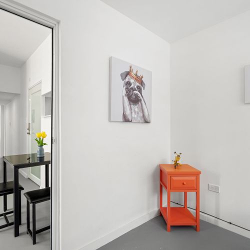 Admire the contemporary dog artwork that adds a personal touch to this well-lit, airy bedroom.