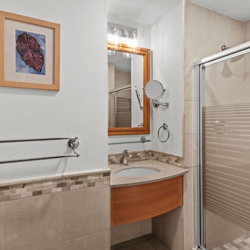 Your pristine bathroom offers a well-lit vanity and a sleek shower design for ultimate comfort.