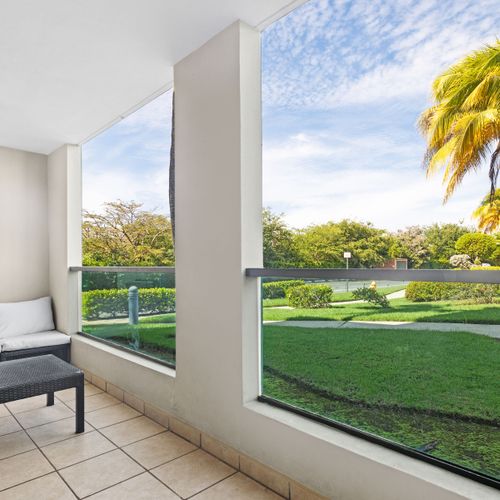 Relax on our bright and inviting balcony, complete with a modern outdoor sofa set and views of lush tropical gardens.