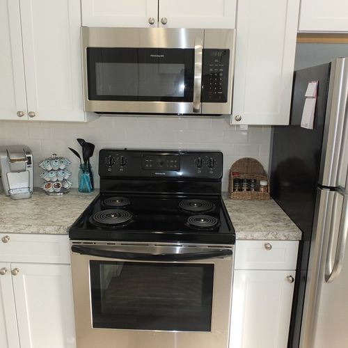 Kitchen:  a close-up of the stainless steel electric range (oven and stovetop) and stainless steel microwave. The kitchen also has a keurig coffee maker that is shown on the left of the photo.