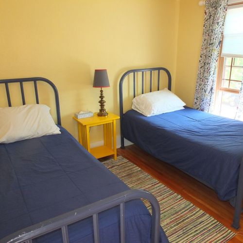 Bedroom #4 (second floor):  this very cute upstairs bedroom features two twin-size beds, a nightstand, lamp, pedestal fan, chair, and a large walk-in closet.