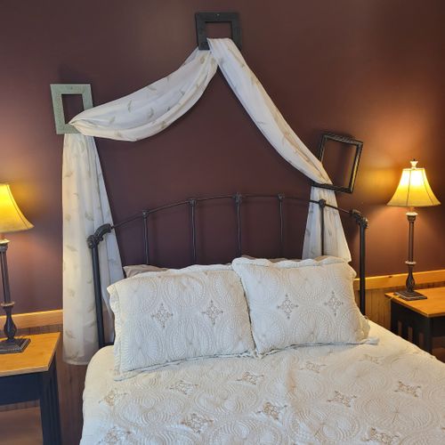 Bedroom #1 (main floor):  features a queen-size bed, dresser, mirror, nightstands, and lamps.