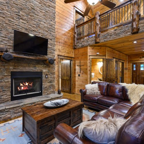 Oversized leather sectional around the stone fireplace!
