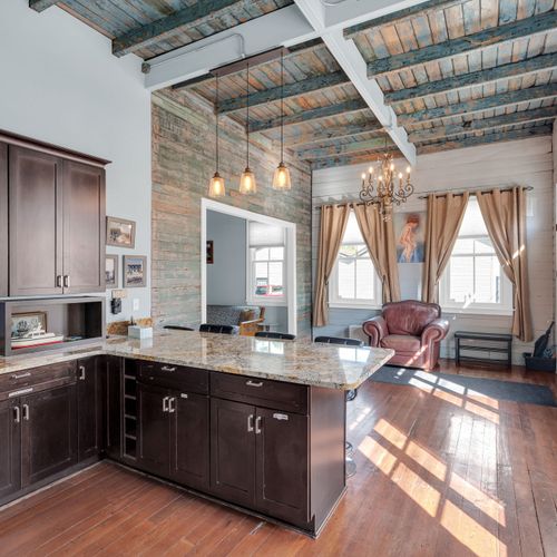Rustic-chic kitchen w/ industrial pendants & rich wood tones.