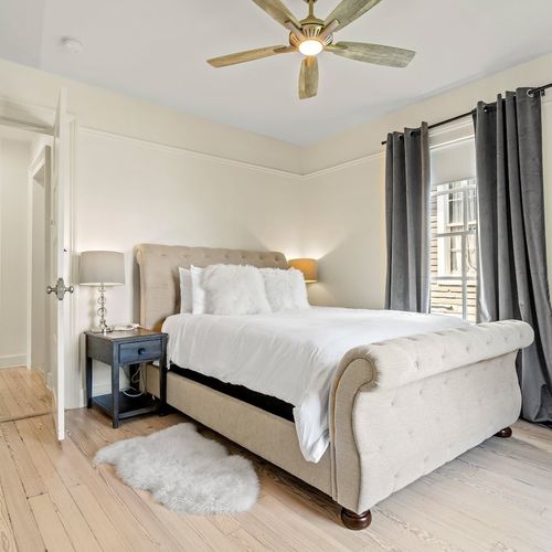 Cozy bedroom w/ a neatly made bed & soft lighting.