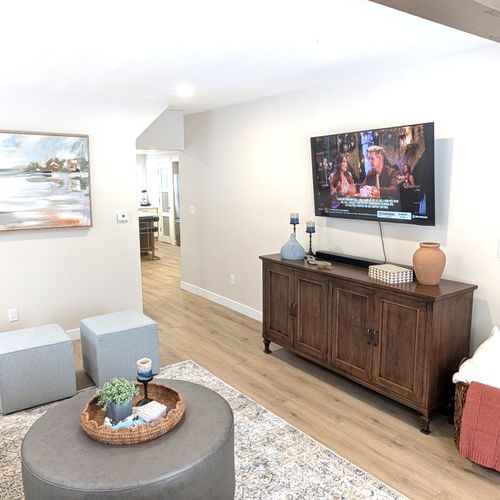 LIVING ROOM:  The home has a gorgeous newly-decorated living room with a sofa, comfy chairs, ottoman, and large screen television