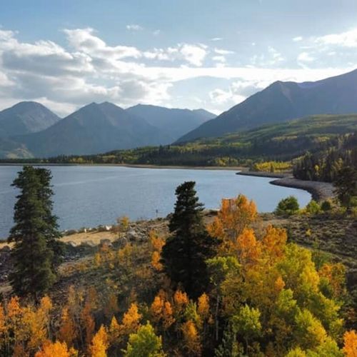 A tapestry of orange, yellow, and red leaves blanket the twin lakes landscape during the autumn season. Photo credit: jake jarvis