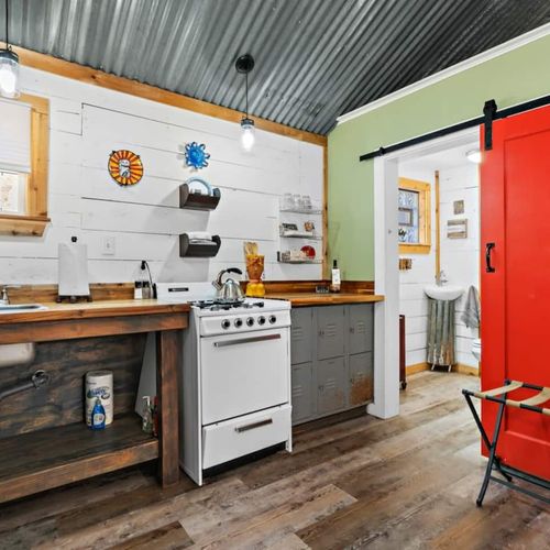 Cottage open concept kitchen and bedroom with it's own private bathroom with shower.