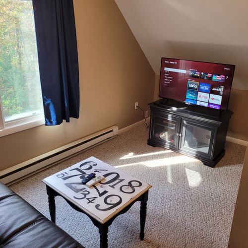 LOFT AREA (SECOND FLOOR):  Very convenient loft area with futon, wall A/C unit, coffee table, chair that unfolds into a bed, and live streaming television (via Sling).