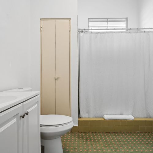 Experience the roomy walk-in shower adorned in soothing neutral shades, providing a peaceful beginning to your morning.