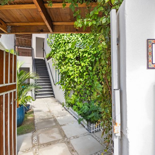 Discover the charming pathway leading to your private retreat, surrounded by lush greenery.