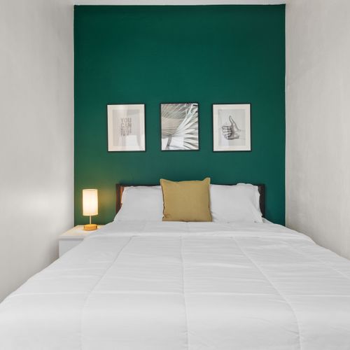 Rest easy in this cozy bedroom with a comfortable bed, flat-screen TV, and bright window.