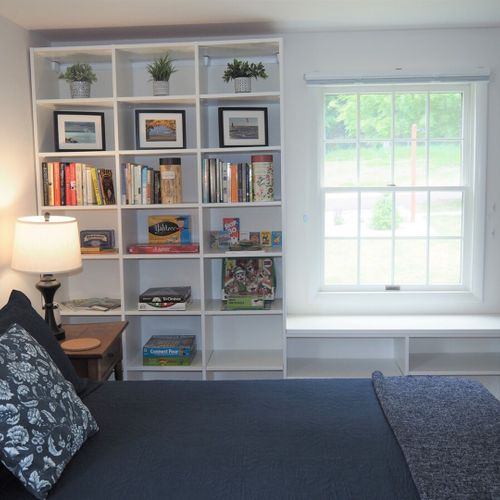 Bedroom #2 (main floor):  large and lovely bedroom with a queen-size bed, rocking chair, nightstands with lamps, two bookcases, a dresser, and a wardrobe.