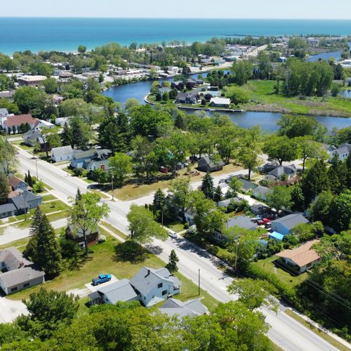 Exterior:  looking southeast with the house in the foreground and the au sable river, downtown oscoda, and lake huron in the background.