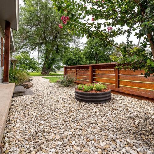 Front porch garden area that leads to the driveway with parking for 2 vehicles and gated