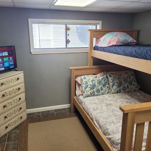 Bedroom:  cute bedroom with a twin-on-full bunk bed, electric heater, fan, 2 dressers, closet, lamp, and a television.
