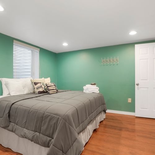 This downstairs bedroom features a queen-sized mattress and lots of light from the egress window.