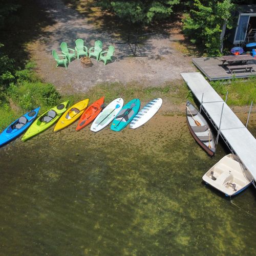Overall:  an aerial photo of the private lakefront showing the dock, bonfire ring, kayaks, paddleboards, canoe, and pedal boat.