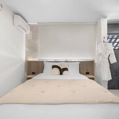 Retreat to this serene bedroom and unwind on the plush bed, surrounded by calming decor and a modern bathroom.