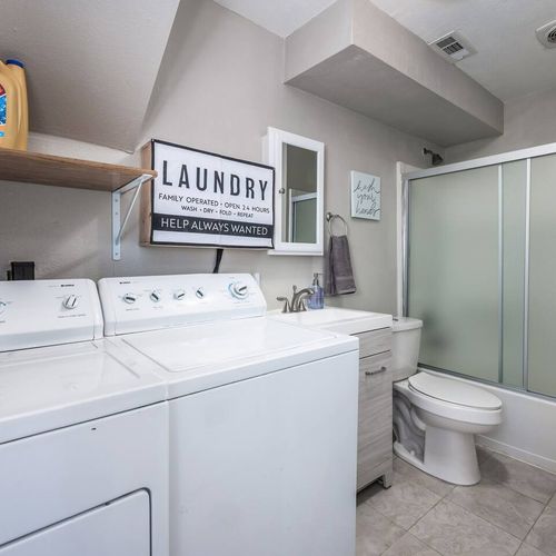 - unique dual use space with washer dryer and fully equipped bathroom
- modern vanity and shower meet shelves stocked with laundry necessities
- efficient and convenient setup perfect for extended or family stays
