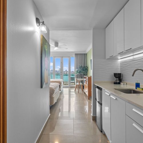 Sleek and functional: a bright white kitchenette designed for easy meal preparation during your stay.