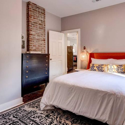 Cozy bedroom w/ warm red curtains & a welcoming bed.