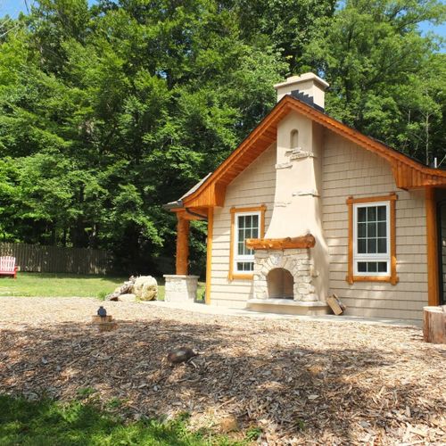 Exterior:  a broader view of the side of the house, showing the nice adirondack chairs and table that are available for guests. (the parking area is next to the chairs. )  the photo also shows part of the lovely hand-made outdoor dining table.