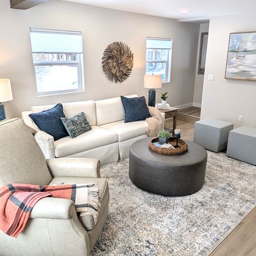 LIVING ROOM:  The home has a gorgeous newly-decorated living room with a sofa, comfy chairs, ottoman, and large screen television