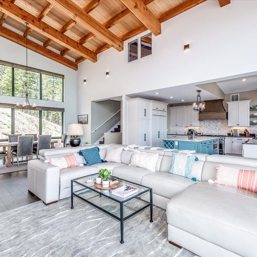 - soaring wood beam ceilings and huge windows fill the space with natural light
- lounge in style on a spacious sectional with soft pillows and forest views
- open concept design flows seamlessly from kitchen to dining area