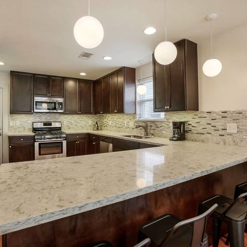 Cook up a storm in this fully-equipped, modern kitchen featuring sleek granite countertops, stainless steel appliances, and ample seating at the breakfast bar. Whether you're preparing a feast or just a quick snack, this kitchen is designed for convenience and style.