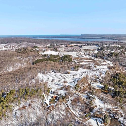 Exterior:  another great aerial photo showing the cabin with platte lake and sleeping bear dunes in the background.