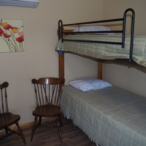 Main room:  includes two twin-on-twin bunk beds, a small dining table, chairs, and a kitchenette / sink.