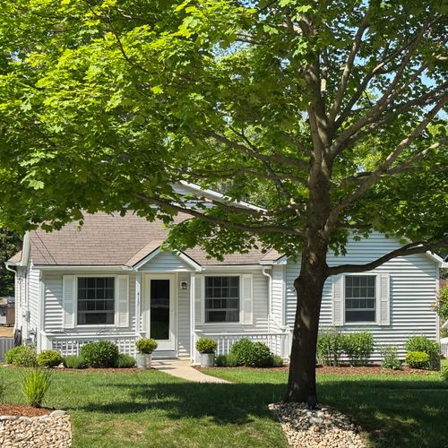 EXTERIOR:  The front of the house in summer.