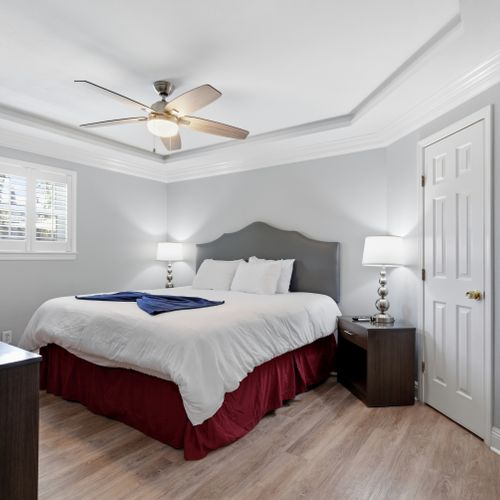 Bright bedroom w/ ceiling fan & soft linens for a peaceful night's sleep.