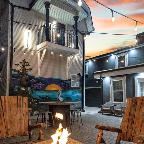 Cozy up by the firepit as the sun sets, surrounded by vibrant local art and twinkling string lights.