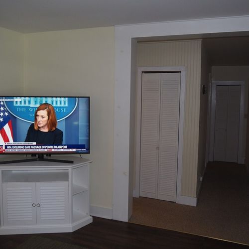 Living room: the apartment has a cozy living room with a sofa, chair, ceiling fan, and live streaming television.