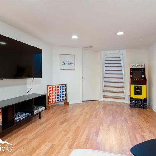 - movie nights and friendly competition await in this entertainment zone
- play retro games, enjoy board favorites, or stream on the wall mounted tv
- clean design, open space, and hardwood floors make it feel fresh and fun