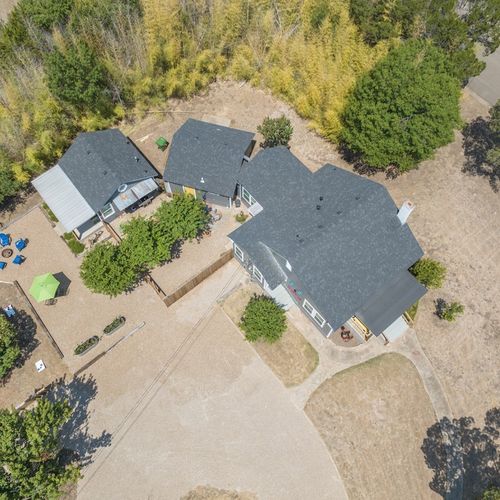 This aerial photo shows the Main House, fenced courtyard area, parking area and Cottage.