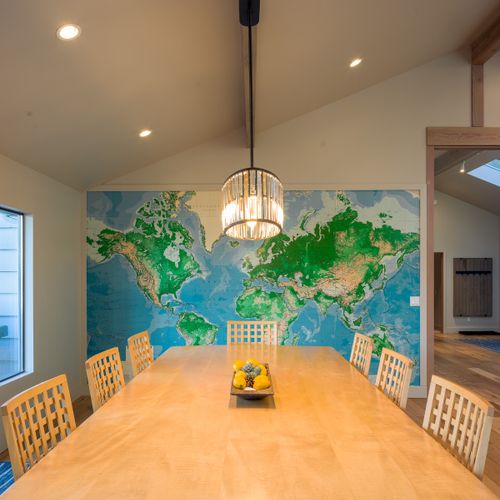 Awesome custom dining table with a world map and open floor plan making meals engaging and comfortable for large gatherings.