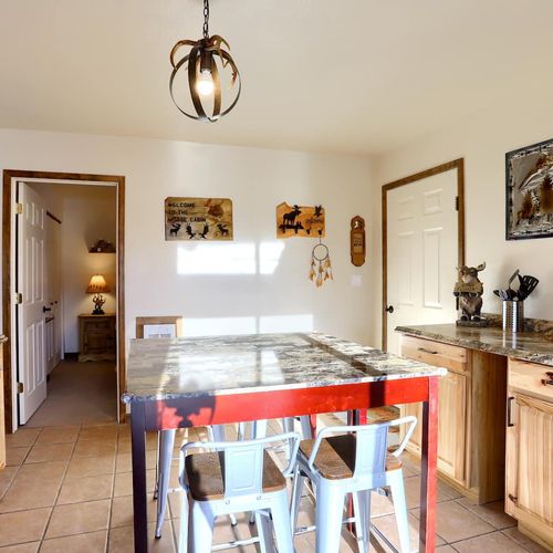 - dining area with a mountain style table and seating for six beneath cozy lighting
- wall art and a dreamcatcher add local flavor to this inviting corner
- easy access to the hallway leads to bedrooms and bathroom areas with ease